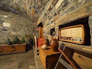 a room with a stone wall with vases on a table at Apartamento Casa Dueso in El Pueyo de Araguás