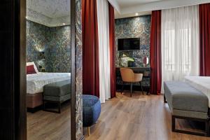 a bedroom with a bed and a desk with a chair at Hotel American-Dinesen in Venice +37 photos