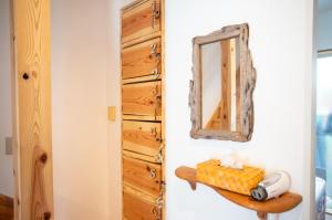 um espelho numa parede ao lado de uma cómoda de madeira em Katsuo Guest House em Kochi