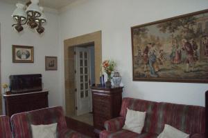uma sala de estar com duas cadeiras e um quadro na parede em Casa Grande do Serrado em Santa Marta de Penaguião