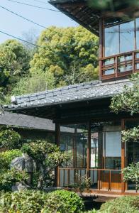 uma casa com janelas de vidro e um telhado em クジラ別館 em Onomichi