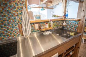 a kitchen with a stainless steel sink and tiles at Katsuo Guest House in Kochi