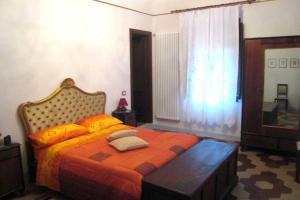 1 dormitorio con 1 cama con manta naranja y ventana en a casa di antonio, en Lucca