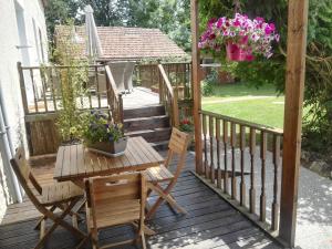 a deck with a table and chairs and a gazebo at Le Chene Vert in Millac