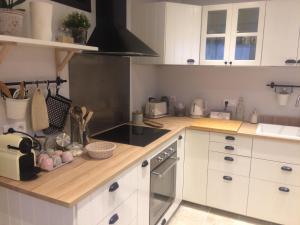 a kitchen with white cabinets and a stove top oven at Chez Adeline in Céreste