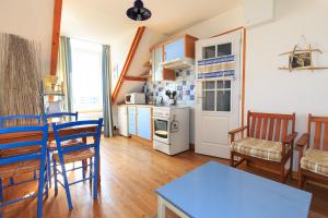 eine Küche und ein Wohnzimmer mit einem Tisch und Stühlen in der Unterkunft Les Transats Chambre et appartements vue mer in Barfleur