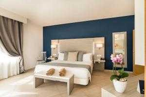 a bedroom with a large bed with a blue wall at Royal Palm Resort & Spa - Adults Only in Playa Jandia