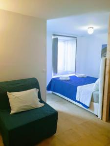a bedroom with a bed and a couch and a window at Casa Visconde de Alcácer in Setúbal