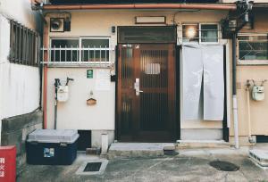 a door of a house with a trash can in front of it at Kyoto Inari Guest House Tonoya villa in Kyoto