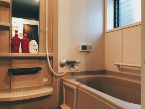 a bathroom with a bath tub and a sink at Kyoto Inari Guest House Tonoya villa in Kyoto +26 photos