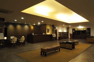 a lobby with a waiting area with a table and chairs at Yakushima Green Hotel in Yakushima