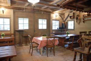 a dining room with a table and chairs and windows at Estate Marjetin dom in Idrija