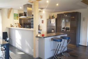 een keuken met een aanrecht en krukken. bij Villa LES FIGUIERS in Cavalaire-sur-Mer
