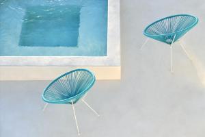 two blue chairs sitting next to a pool at Ciel Villas Paros in Pounda