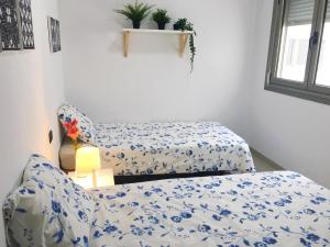 una camera con letto e lenzuola bianche e blu di Farray Beach Flat III by Canary365 a Las Palmas de Gran Canaria