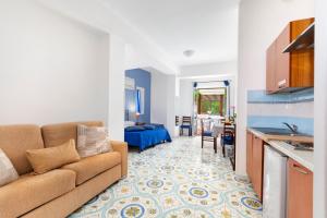 a living room with a couch and a kitchen at Sorrento Marida Rooms in Sorrento