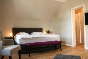 Dormitorio con cama grande y banco púrpura en Stadt Apartments Burg Fehmarn, en Burg auf Fehmarn