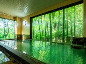 een zwembad in een kamer met bomen op de achtergrond bij Hakone Onsen Sanso Nakamura in Hakone