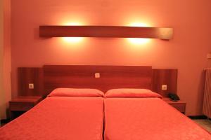 Un dormitorio con una gran cama roja con sábanas rojas en Hotel Haromar, en Calella