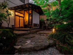 a small house with a stone path leading to it at Hakone Onsen Sanso Nakamura in Hakone