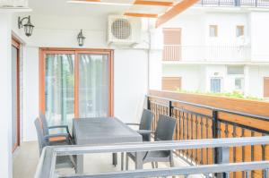 a patio with a table and chairs on a balcony at Palm Studios in Limenas