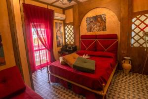 a bedroom with a red bed and a window at Nives Bed & Breakfast in Pompei