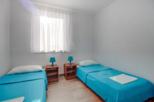 a room with two beds and two night stands at Apartment Mikic in Čunski