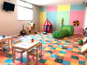 a room with a play area with tables and a play tent at Hotel Alda Bueumar in Bueu