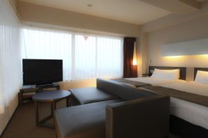 Habitación de hotel con cama y TV de pantalla plana. en Hotel Inside Numazu Inter, en Numazu