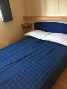 a blue bed with white pillows and a blue headboard at Camping Verde in Massa