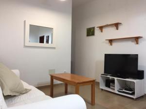 a living room with a tv and a table at Es Magraner in Cala Saona