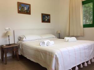 a bedroom with a large white bed with towels on it at Es Magraner in Cala Saona