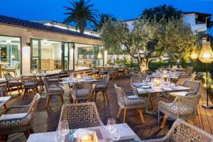 a restaurant with tables and chairs on a deck at Philoxenia Hotel in Psakoudia