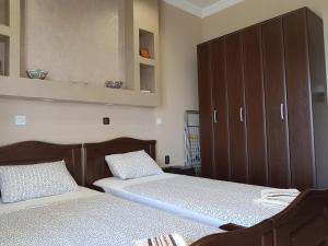 a bedroom with two beds and a cabinet at Luxury apartment on the first line ! in Nea Kalikratia