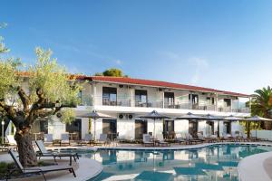 a hotel with a pool and tables and chairs at Philoxenia Hotel in Psakoudia