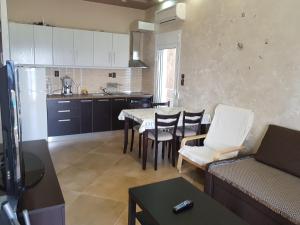 a kitchen and living room with a table and chairs at Luxury apartment on the first line ! in Nea Kalikratia