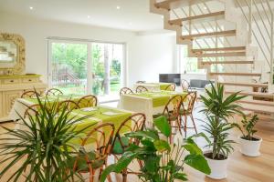 une salle à manger avec des tables, des chaises et des plantes dans l'établissement Villa Giulia, à Crotone