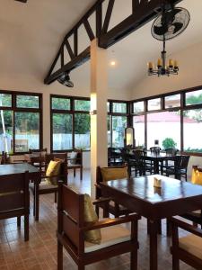 a dining room with tables and chairs and windows at Alona Vikings Lodge in Panglao Island