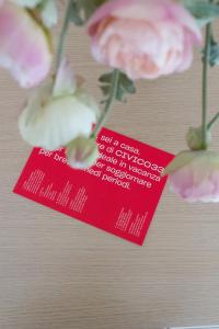 une carte rouge avec des fleurs roses sur une table dans l'établissement CIVICO33, à Rocca Imperiale