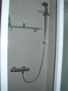 a shower with a hose and a shelf in a bathroom at PIETRAMURATA APPARTAMENTO VISTA MONTAGNA terzo piano in Dro
