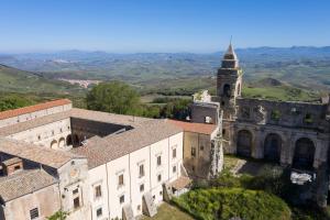 Abbazia Santa Maria del Bosco في Contessa Entellina: مبنى قديم فيه برج وكنيسة