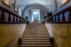 una escalera en un edificio antiguo con ventana en Abbazia Santa Maria del Bosco, en Contessa Entellina