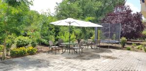 un patio con mesa, sillas y sombrilla en Villa Sky, en Mamaia