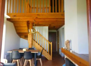 a dining room with a wooden staircase and a table and chairs at Preciosa casa adosada con piscina in Sainte-Léocadie +34 photos