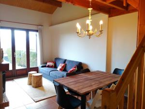a living room with a wooden table and a blue couch at Preciosa casa adosada con piscina in Sainte-Léocadie