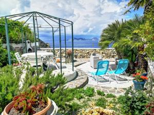 een patio met stoelen en planten en de oceaan bij Turistcasa- Villa Anna in Ponza