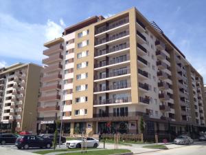 a large building with cars parked in a parking lot at Apartament Marcel - Coresi Mall in Braşov