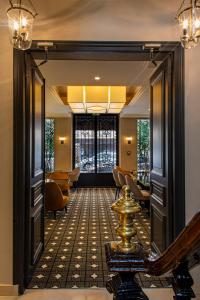 a hallway with a door leading into a room with chairs at Lenox Montparnasse in Paris