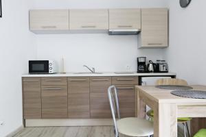 a kitchen with wooden cabinets and a table at Villa Juliette by Baltic Home in Świnoujście