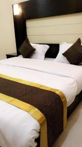 two beds in a hotel room with white sheets and pillows at نزل الصفوة للأجنحة المفروشه بأبها in Abha